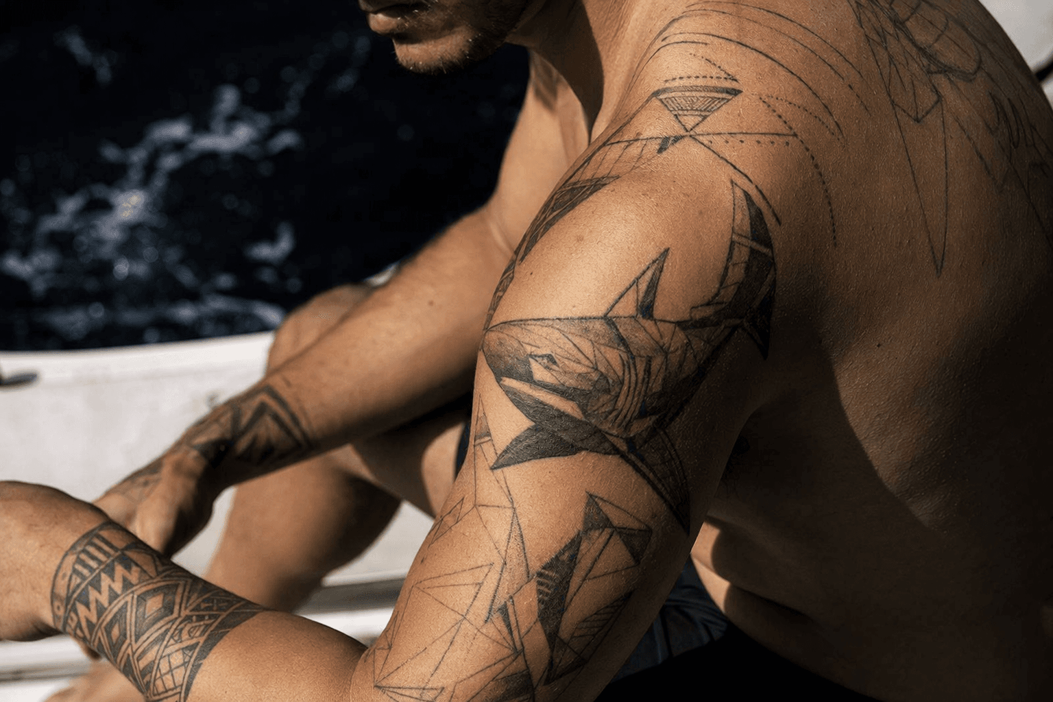 Shark tattoos blend ancient strength, conservation urgency, and geometric design themes