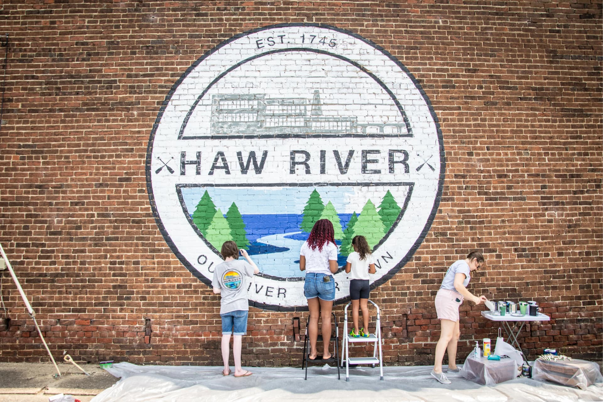 Community members paint Haw River logo mural at historical museum