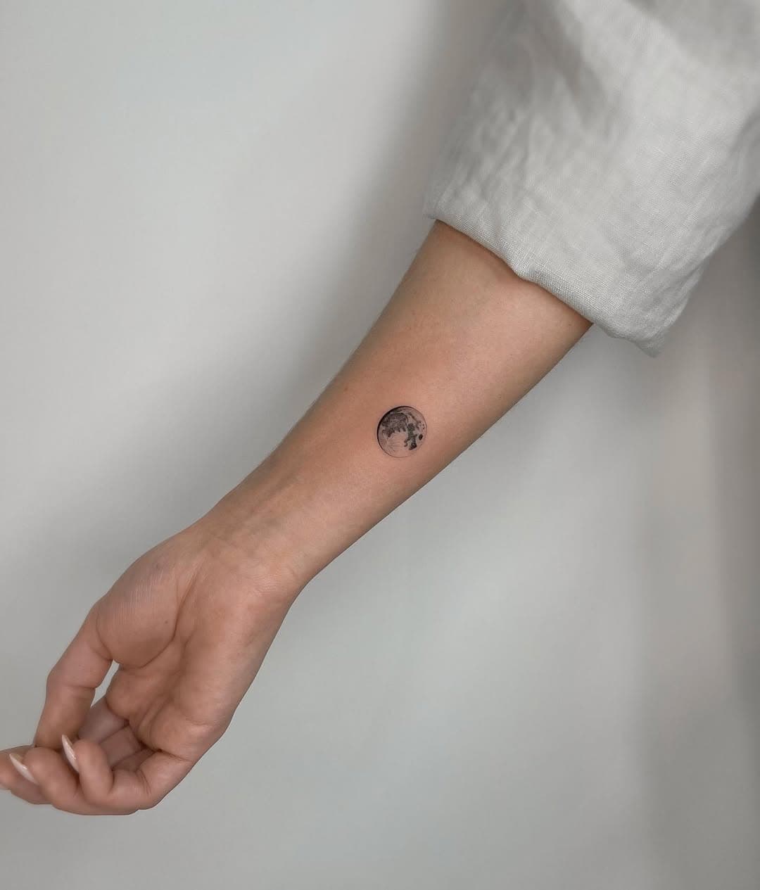 Moon tattoos mix sacred geometry, cosmic symbolism, and minimalist style