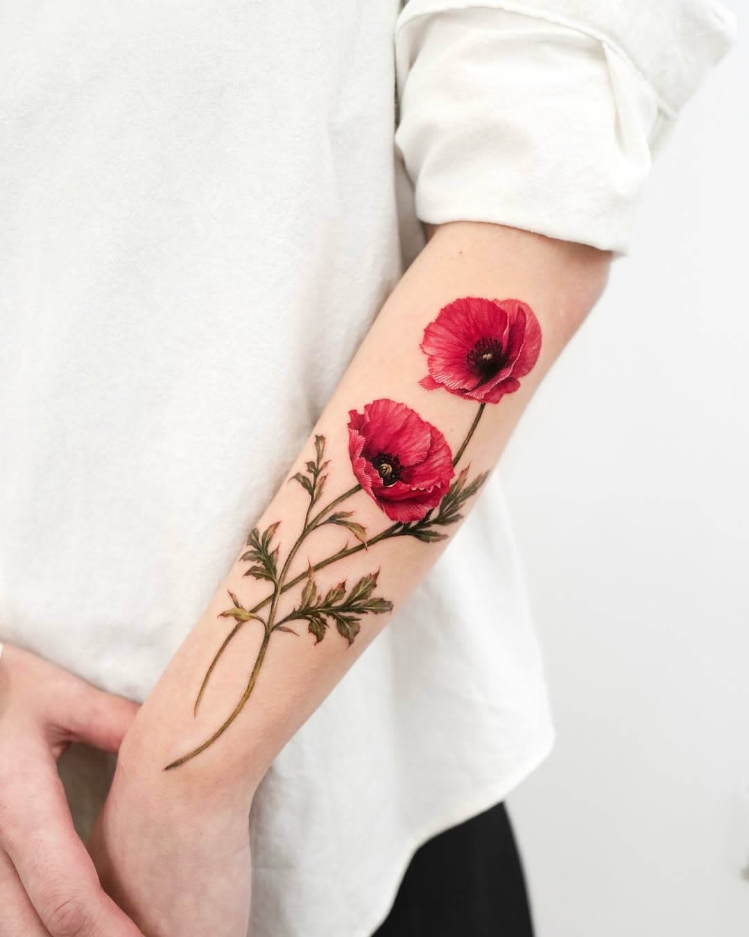 Flower tattoos soften geometric sleeves with cleaner linework and flow