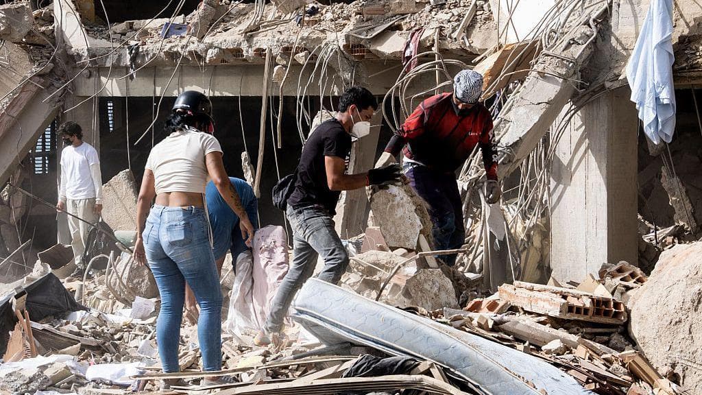 Families wait beside rubble as Venezuela quake toll climbs and survivors trapped