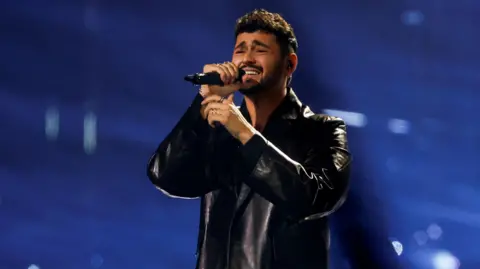 Israel’s Eurovision entry advances after boos, cheers, and protest disruption