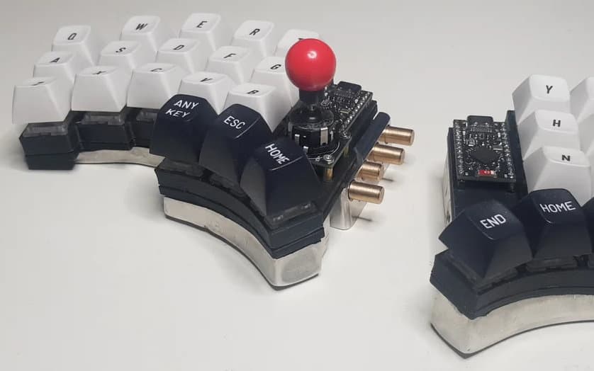 Handwired split keyboard uses molded tin tenting weights and latching Bluetooth selector