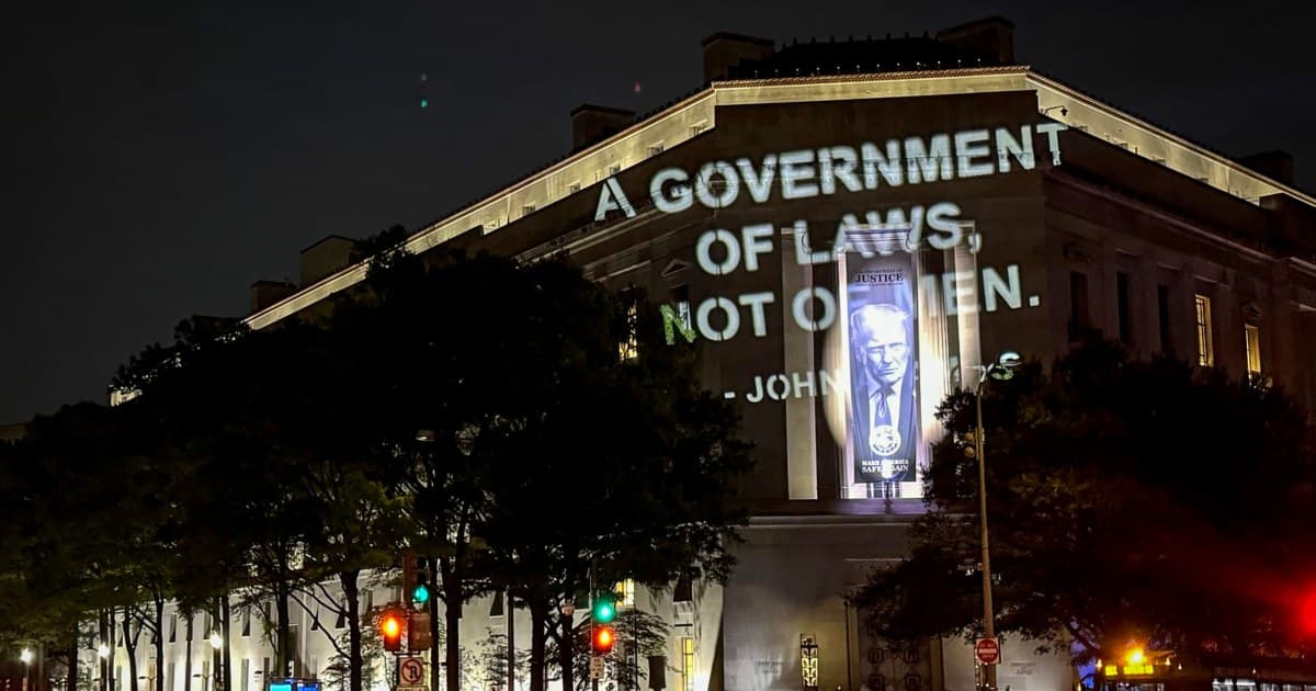 Protesters project Adams quote on Justice Department over anti-weaponization fund